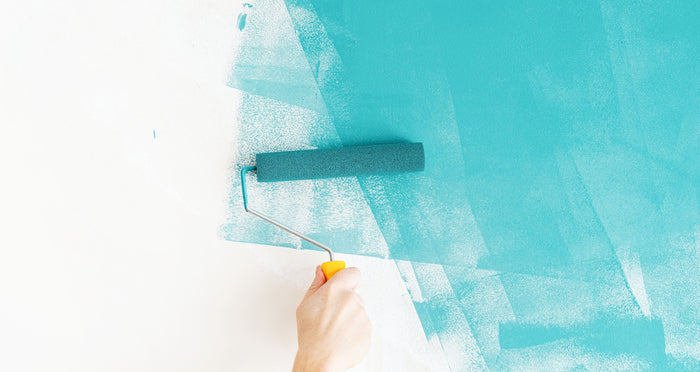 Blaue Wandfarbe wird mit Farbrolle aufgetragen